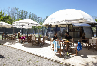 Espace café en plein air au Tamarit Park Resort 2 PATIO en Espagne, avec clients assis sous des parasols.