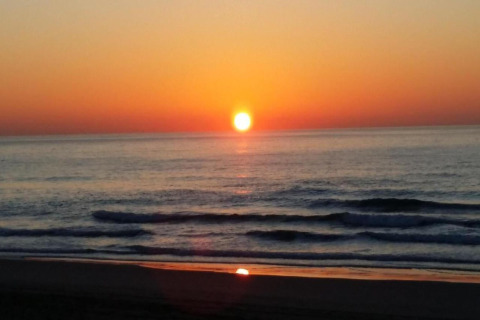 Coucher de soleil sur la mer depuis Tamarit Park Resort 2 PATIO en Espagne, reflets sur les vagues douces.