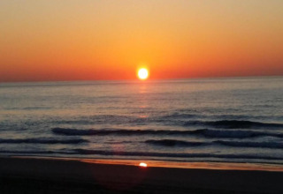 Coucher de soleil sur la mer depuis Tamarit Park Resort 2 PATIO en Espagne, reflets sur les vagues douces.