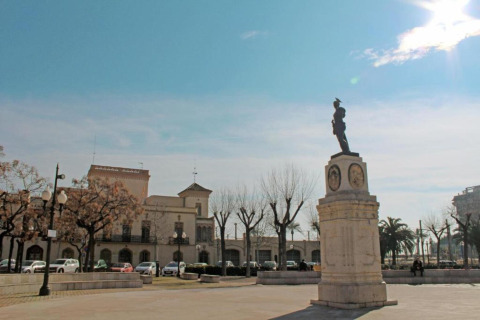 Place ensoleillée avec statue et arbres près du Tamarit Park Resort 2 PATIO en Espagne, ambiance paisible.