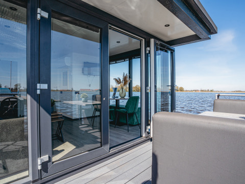 Casa flotante moderna con puertas de cristal y vistas al agua en Marina Uitgeest, Países Bajos.