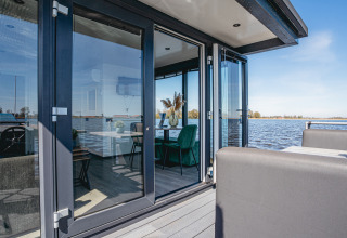 Casa flotante moderna con puertas de cristal y vistas al agua en Marina Uitgeest, Países Bajos.