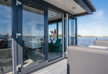 Hausboot mit großen Glasfronten und Blick auf das Wasser bei Marina Uitgeest, Niederlande, Havenlodge Plus.