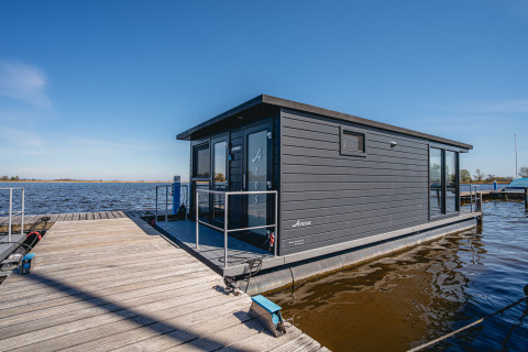 Moderne husbåd, kaldet Havenlodge Plus, ligger ved Marina Uitgeest i Holland på en solrig dag.