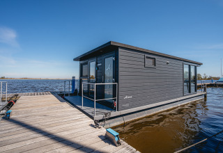 Moderne husbåd, kaldet Havenlodge Plus, ligger ved Marina Uitgeest i Holland på en solrig dag.