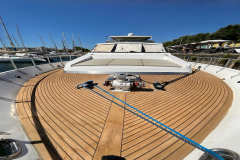 View from the deck of houseboat Yacht Aquamarina, featuring wooden flooring, rope, and marina backdrop.