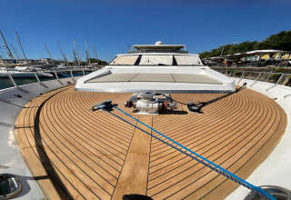 View from the deck of houseboat Yacht Aquamarina, featuring wooden flooring, rope, and marina backdrop.