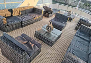 Outdoor lounge area on Yacht Aquamarina houseboat with modern wicker furniture and water views.