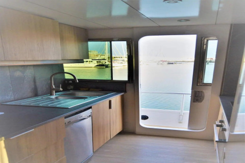 Modern kitchen on the houseboat Yacht Aquamarina in France, featuring a marina view through the window.