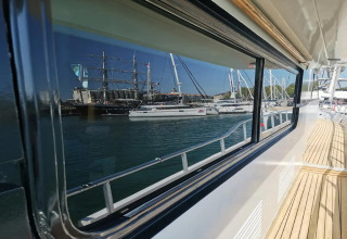 View from the houseboat 'Yacht aquamarina' in France, with sailboats reflected in the window.