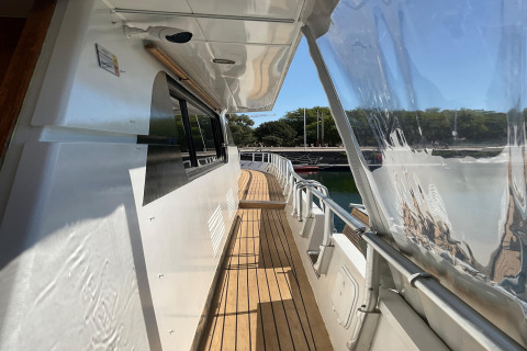 Side walkway on the houseboat Yacht Aquamarina, featuring a wooden deck, railings, and water view.