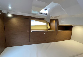 Modern cabin interior on Yacht Aquamarina houseboat featuring wood paneling, bed, and skylight.