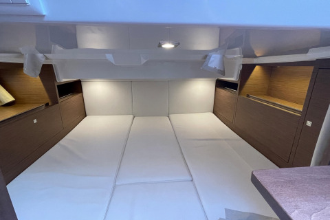 Interior view of a wide sleeping area with wood-panel accents inside the houseboat Yacht Aquamarina.