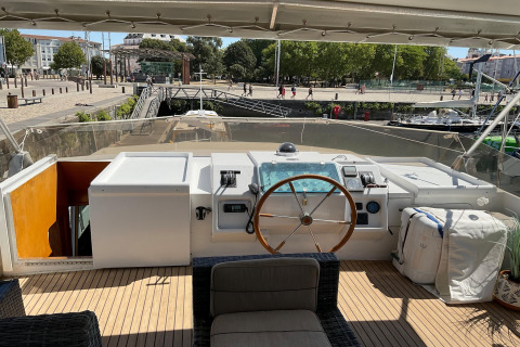 View from the helm of the houseboat Yacht Aquamarina, showing the harbor, promenade, and city beyond.