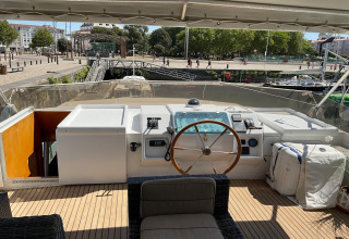 View from the helm of the houseboat Yacht Aquamarina, showing the harbor, promenade, and city beyond.