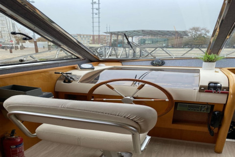 Interior view of the helm on houseboat Yacht Aquamarina, showing the steering wheel and controls.