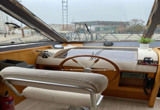 Interior view of the helm on houseboat Yacht Aquamarina, showing the steering wheel and controls.