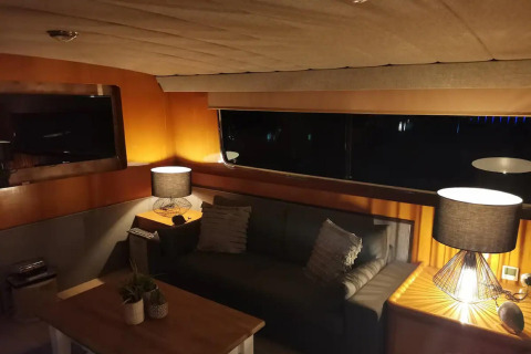 Cozy living area on the Yacht Aquamarina houseboat in France featuring a sofa and two lamps.