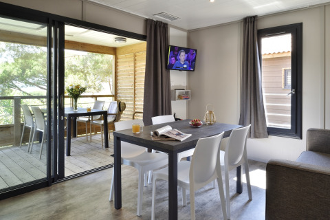 Interior moderno de un chalet en Résidence U Livanti Belvédère Campomoro, Francia, con comedor y terraza.