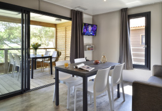 Interior moderno de un chalet en Résidence U Livanti Belvédère Campomoro, Francia, con comedor y terraza.