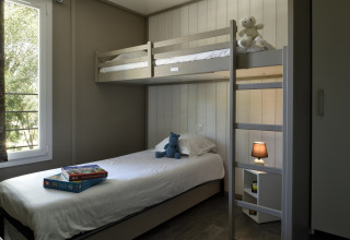 Dormitorio acogedor en Résidence U Livanti Belvédère Campomoro, Francia, con literas y juegos de mesa.