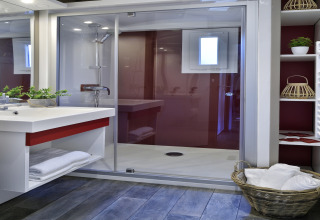 Baño moderno en Résidence U Livanti Belvédère Campomoro - Chalet Casane, con ducha y cesta de toallas.