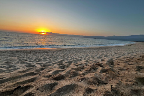 Hermosa puesta de sol sobre el océano vista desde la playa en Résidence U Livanti Belvédère Campomoro, Francia.