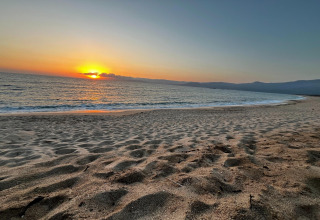 Hermosa puesta de sol sobre el océano vista desde la playa en Résidence U Livanti Belvédère Campomoro, Francia.