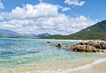 Prachtig strandzicht met helderblauw water en bergen bij Résidence U Livanti Belvédère Campomoro, Frankrijk.
