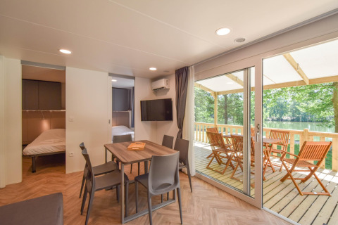 Vista interior de la casa móvil Cottage «6p» en Francia con comedor, dormitorios y terraza con vistas al lago.