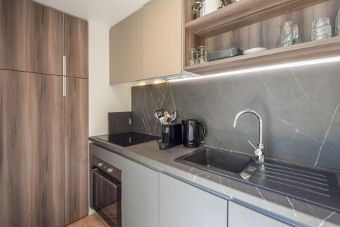 Moderne keuken in Cottage «6p» mobilhome in Frankrijk met houtlook kasten, gootsteen en rekken.