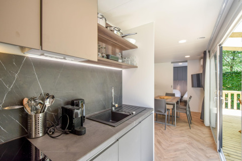 Moderne køkken og spisestue i mobilhome Cottage 6p i Frankrig med stort vindue ud til terrasse.