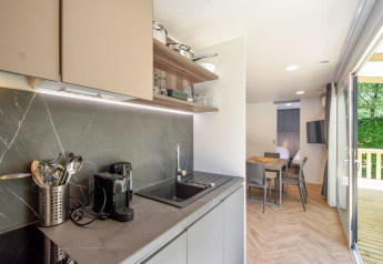 Moderne Küche und Essbereich im Mobilheim Cottage 6p in Frankreich, mit Blick auf eine Terrasse.