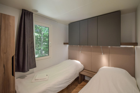 Moderne stacaravan Cottage 6p in Frankrijk, met twee enkele bedden, raam, kasten en strakke inrichting.
