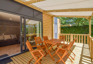 Houten terras met zes stoelen en tafel aan mobilhome Cottage «6p» in Frankrijk, met zicht op natuur.
