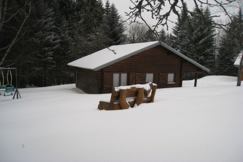 Chalet di legno chiamato 'Ronds Chetys' coperto di neve, circondato da pini in Francia, scena invernale.