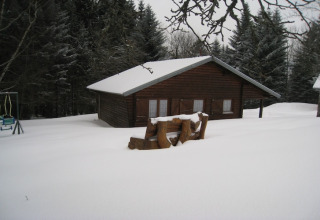 Chalet di legno chiamato 'Ronds Chetys' coperto di neve, circondato da pini in Francia, scena invernale.