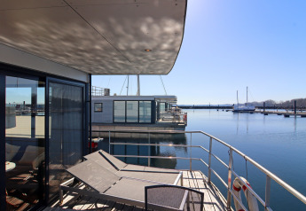 Terrazza di moderna houseboat con lettini e vista marina, Houseboat «Familiy & Friends LP 1» in Germania.
