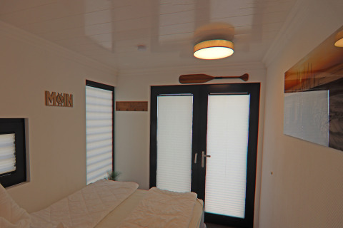 Bedroom on Houseboat Family & Friends LP 1 with maritime decor, double doors and an oar above the door.