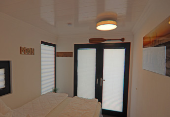 Dormitorio en la casa flotante Family & Friends LP 1 con decoración náutica, puertas dobles y un remo mural.