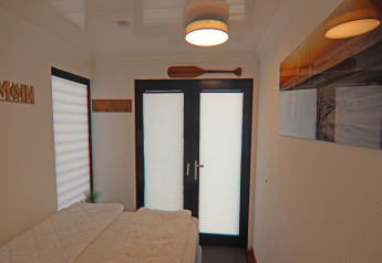 Camera da letto su houseboat con letto, doppie porte in vetro e quadro, in Family & Friends, Germania.