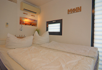 Camera luminosa e accogliente su una houseboat con letto matrimoniale, decorazioni e piccola finestra.