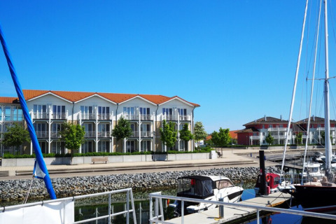 Harbor view with boats and modern apartments in the background, as seen from Houseboat Family & Friends in Germany.