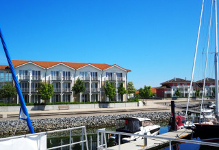 Harbor view with boats and modern apartments in the background, as seen from Houseboat Family & Friends in Germany.