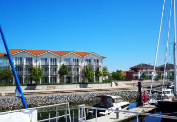Harbor view with boats and modern apartments in the background, as seen from Houseboat Family & Friends in Germany.
