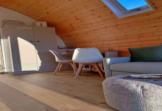 Modern houten pod-interieur met dakraam, sofa, stoelen en kast bij Hundle Dale, Verenigd Koninkrijk.