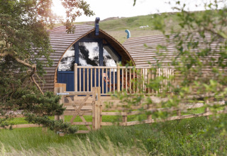 Knusse houten glamping-pod met omheind terras bij Blackcleugh Glamping, Verenigd Koninkrijk, omgeven door natuur.