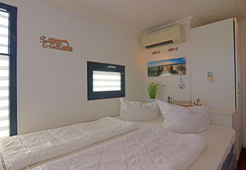 Slaapkamer op woonboot 'Familiy & Friends LP 1' in Duitsland met tweepersoonsbed en maritiem thema.