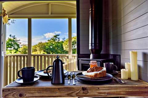 Petit déjeuner dans la 'Elen' Gypsy Hut : café, gâteau, bougies et vue sur la nature, Royaume-Uni.