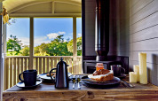 Ontbijttafereel in de 'Elen' Gypsy Hut met koffie, gebak en uitzicht op de natuur in het Verenigd Koninkrijk.